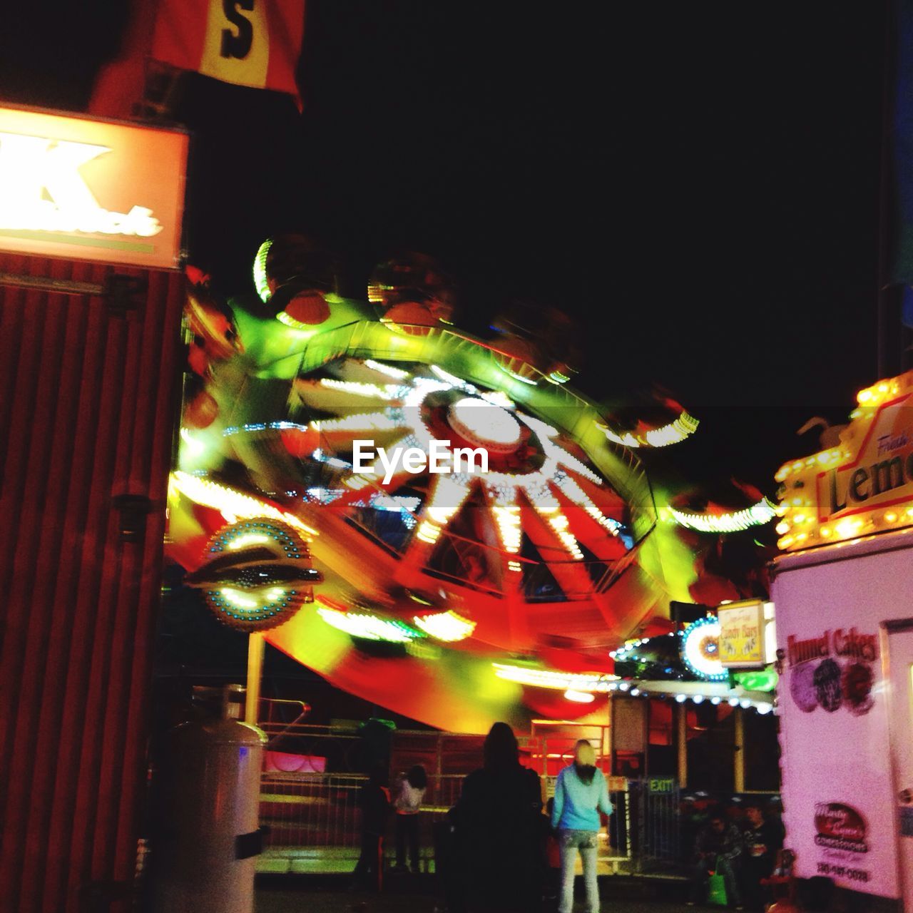 People against spinning amusement park ride at night