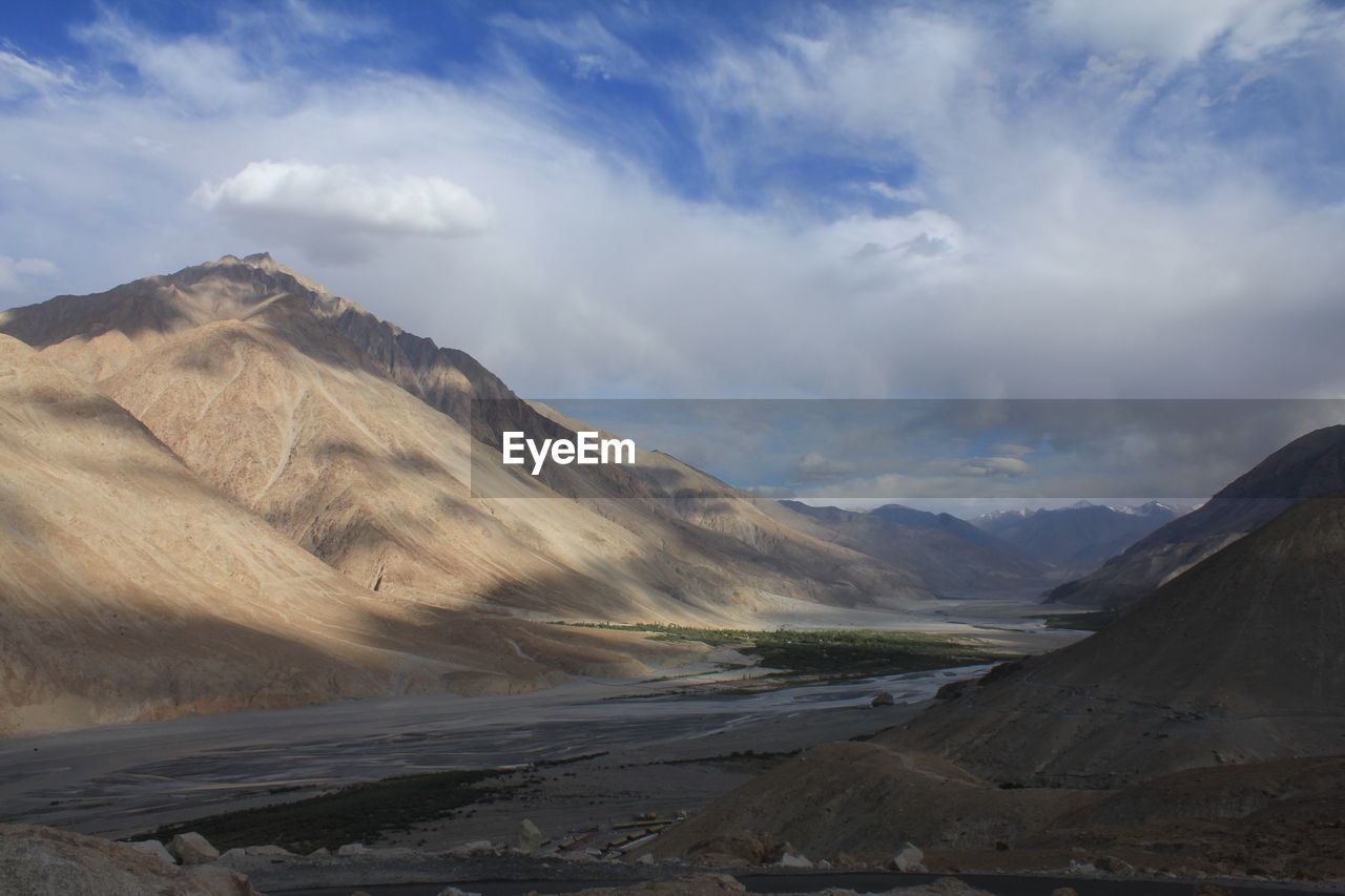 Scenic view of mountains against cloudy sky