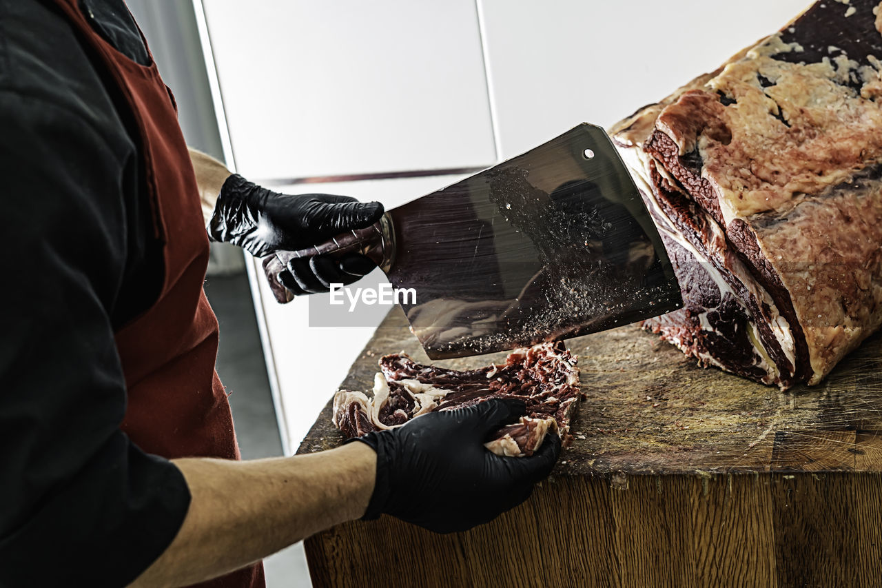 Butcher preparing and cutting mea