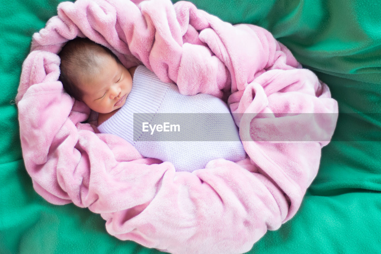 Close-up of baby girl sleeping on bed