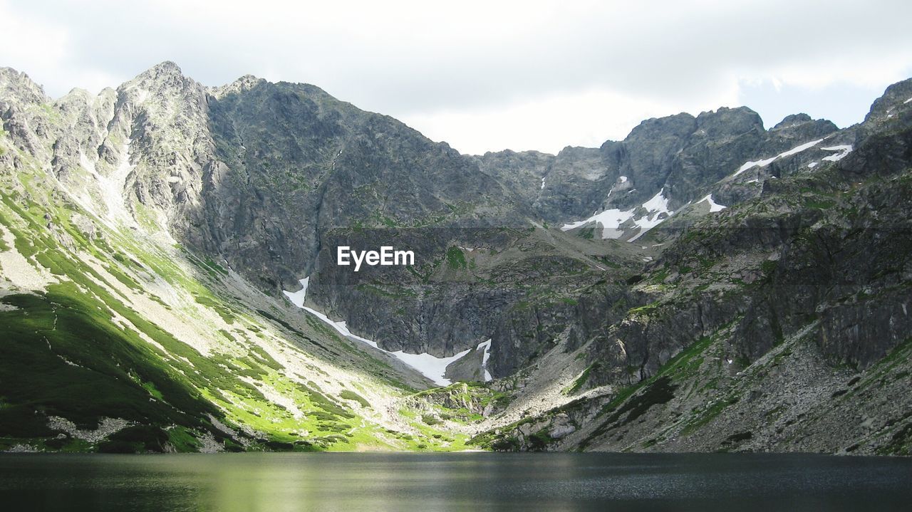 Scenic view of lake and mountains against sky