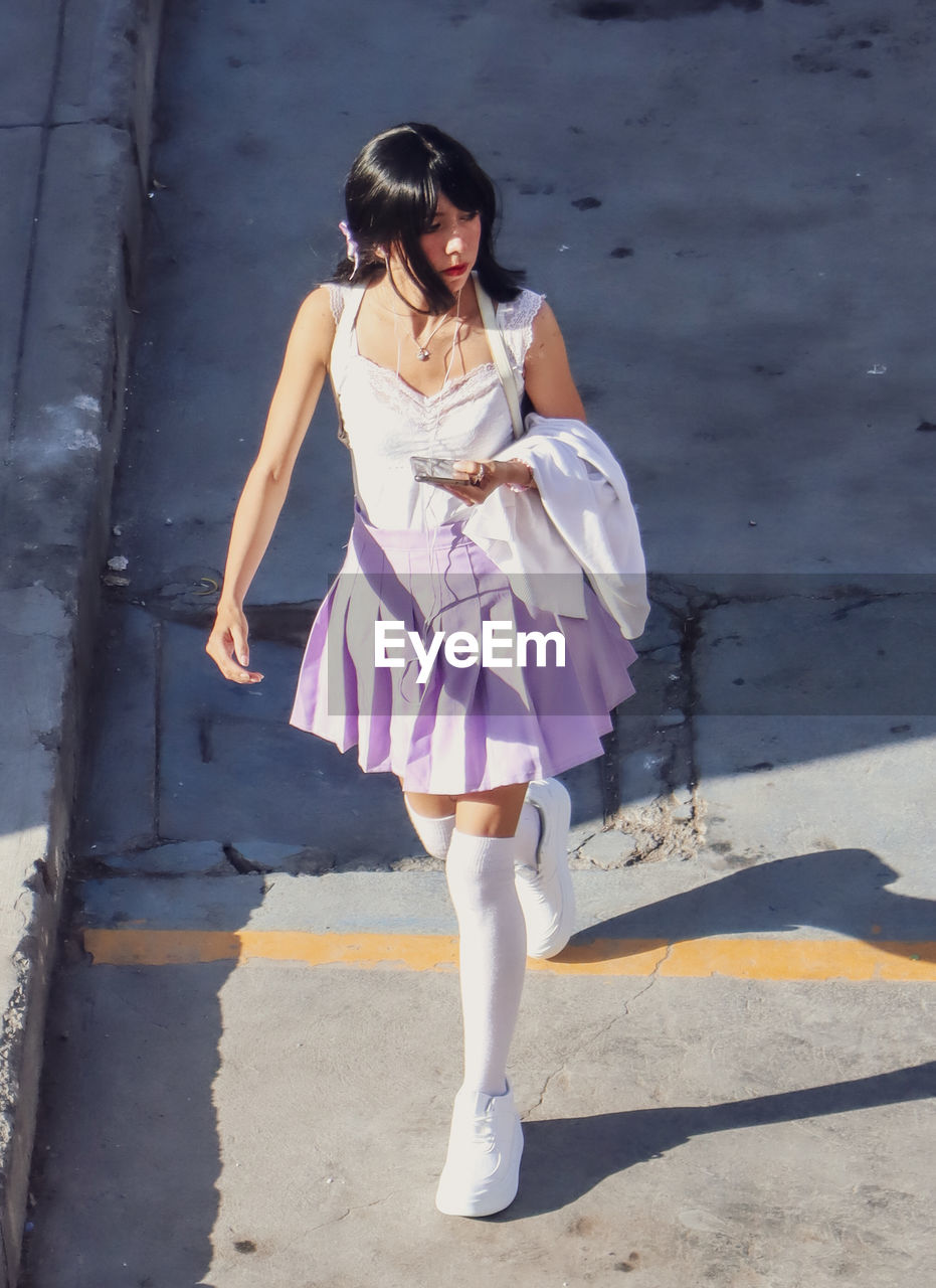 Portrait of young woman walking on street