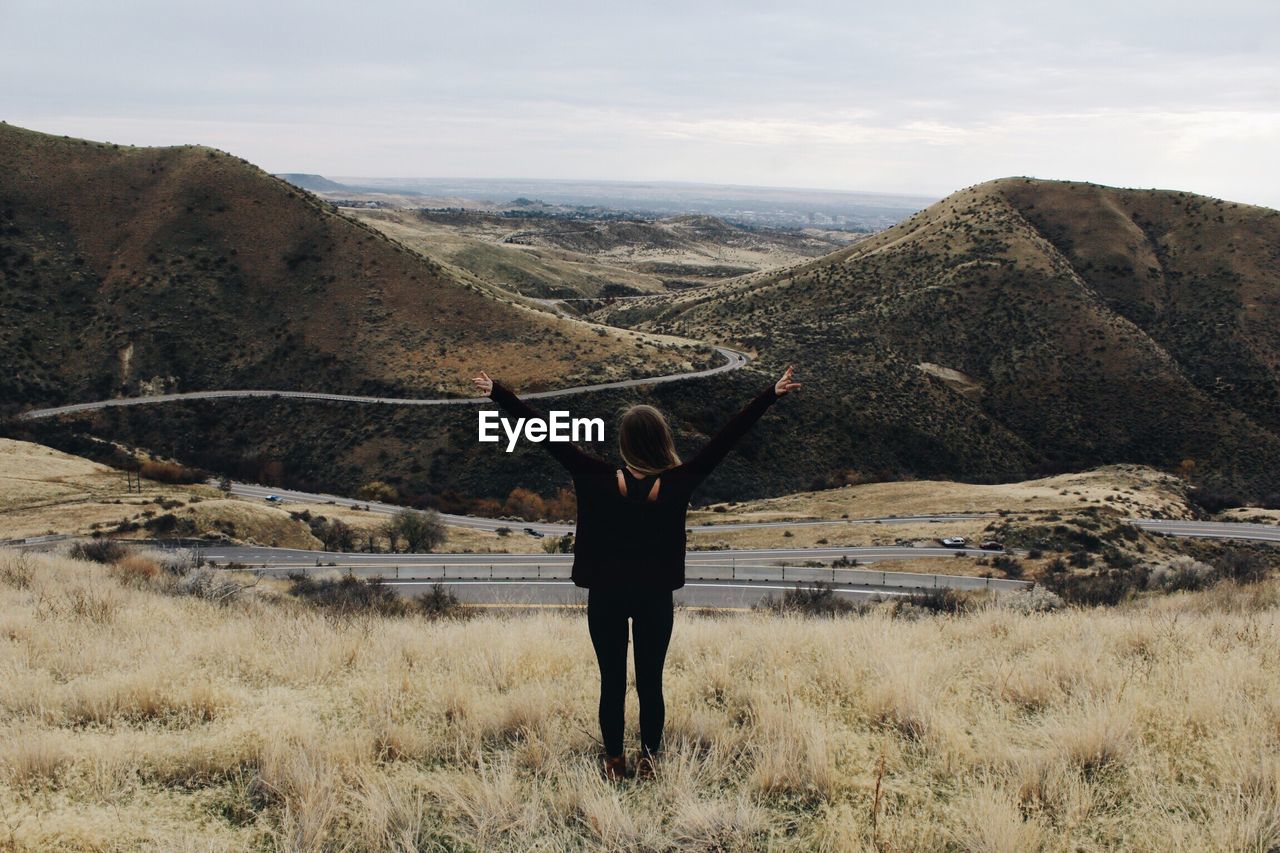 Rear view of woman on mountain against sky