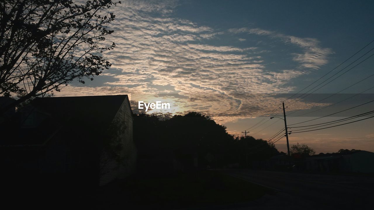 Electricity pylon against sky at sunset