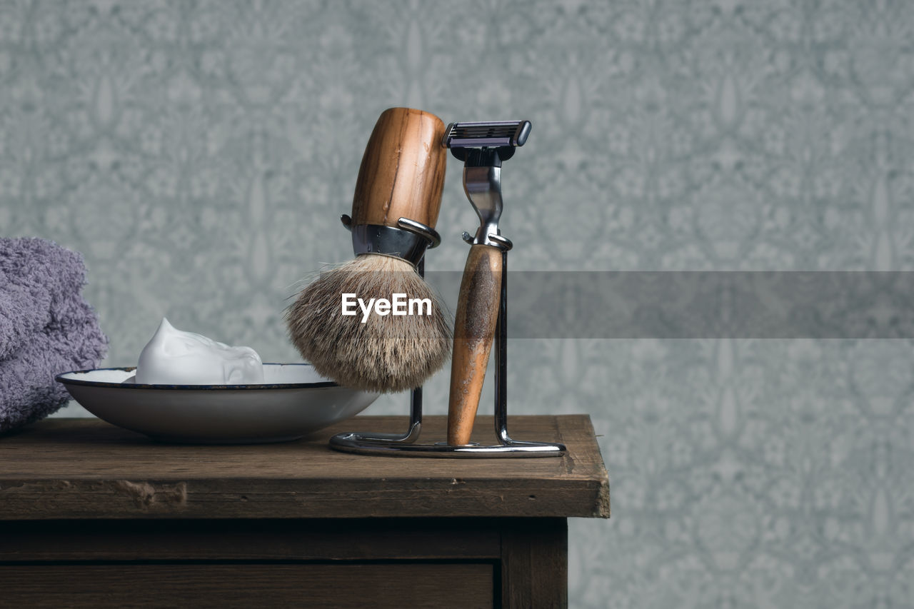 Close-up of shaving equipment on table