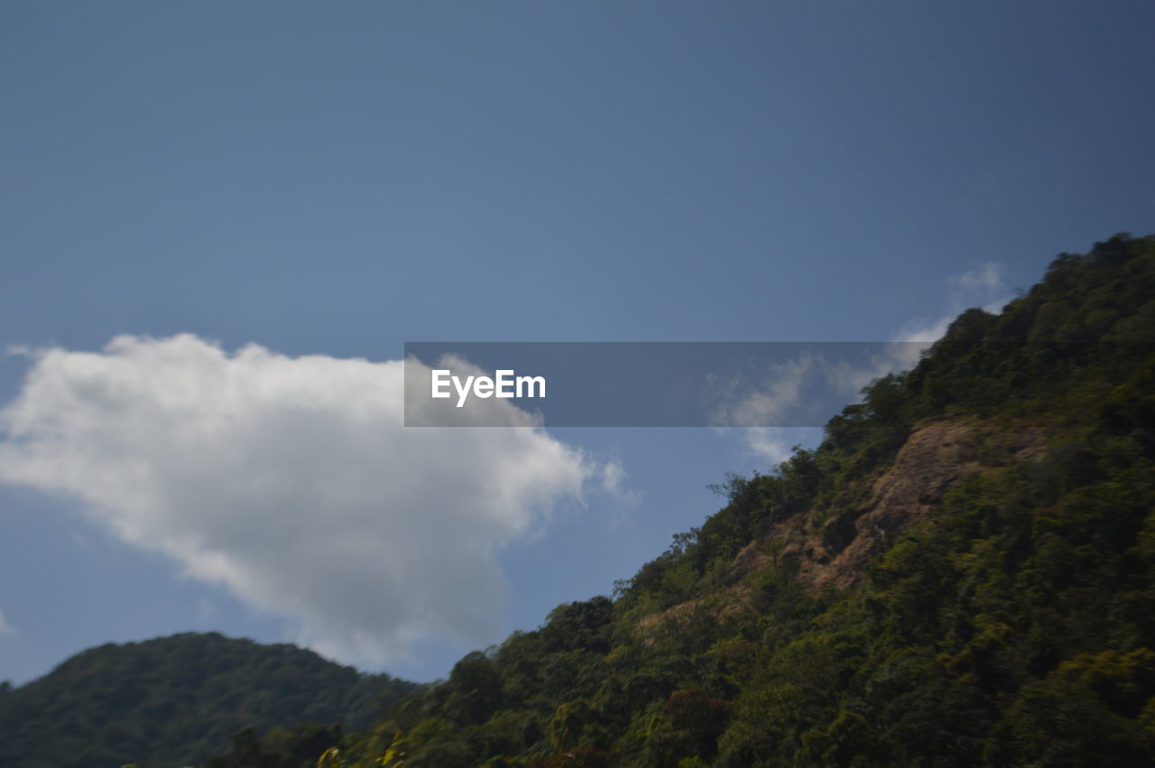 LOW ANGLE VIEW OF MOUNTAINS AGAINST BLUE SKY