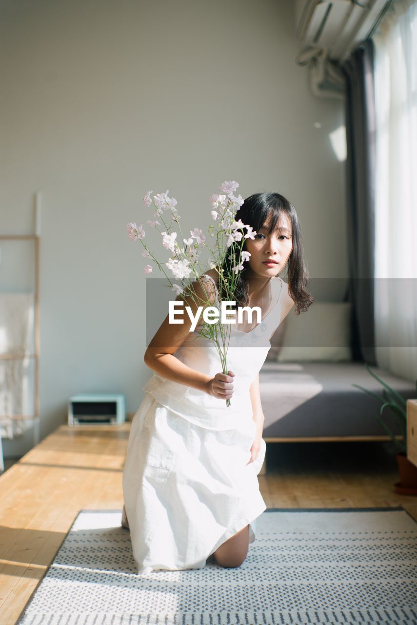 Portrait of woman with flowers at home