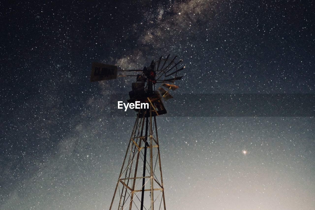 Low angle view of traditional windmill against star field at night