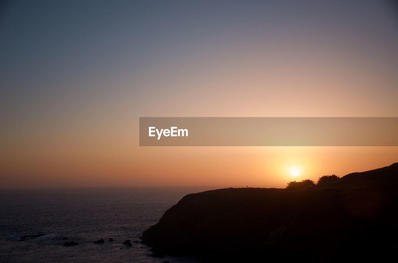 SCENIC VIEW OF SEA AGAINST ORANGE SKY