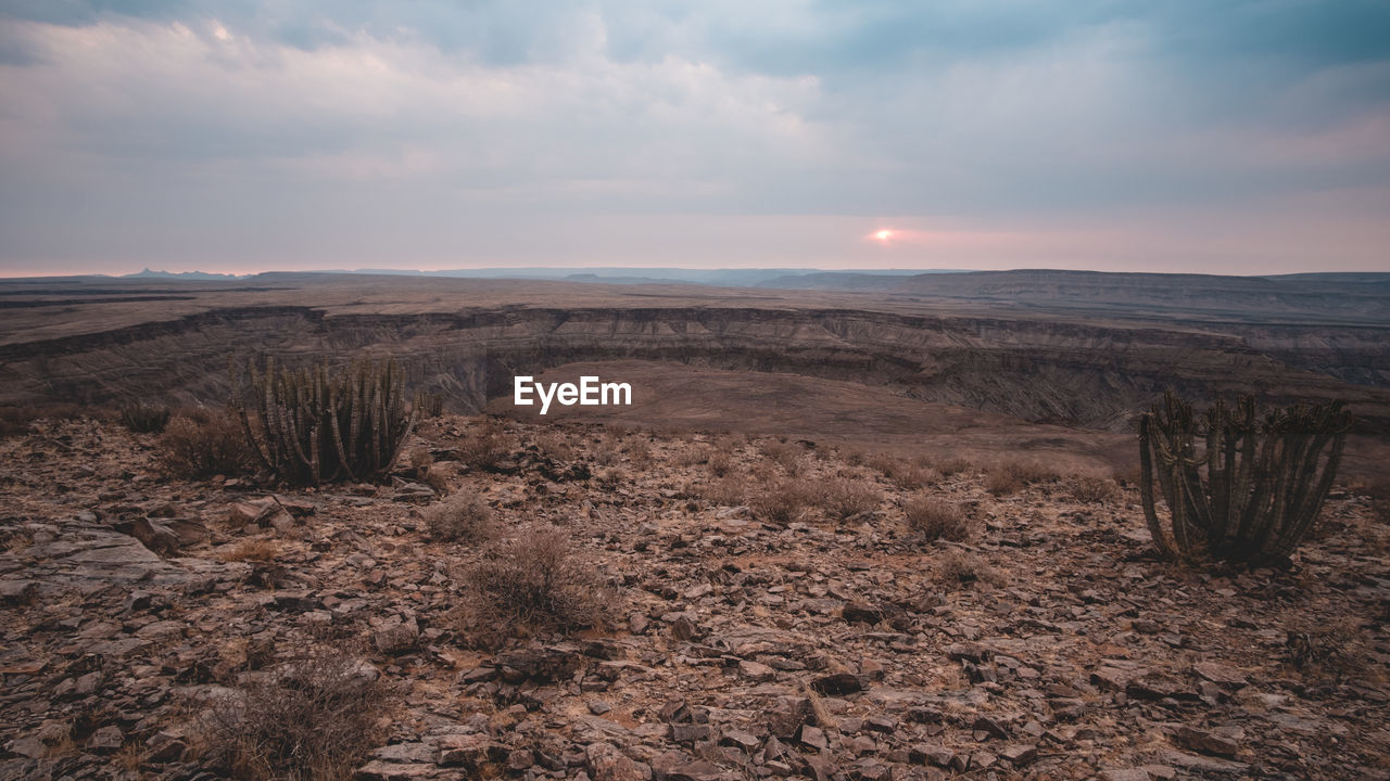SCENIC VIEW OF LAND AGAINST SKY DURING SUNSET
