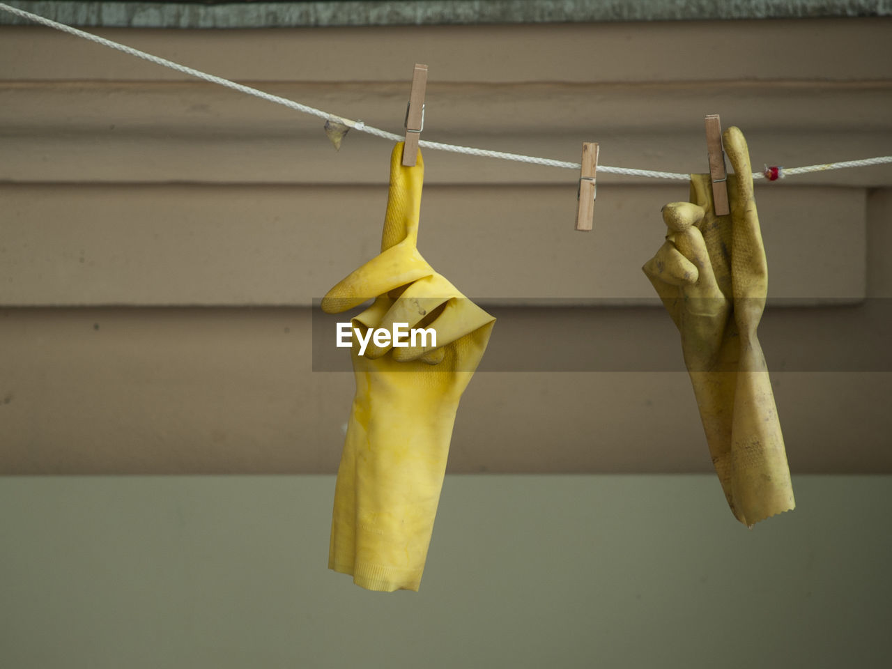 CLOSE-UP OF CLOTHES HANGING ON CLOTHESLINE AGAINST WALL