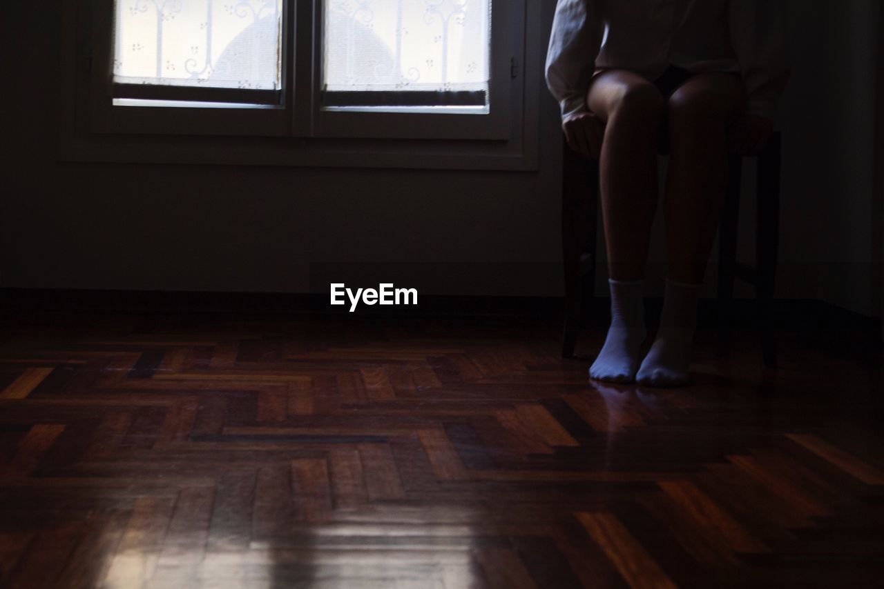 HIGH ANGLE VIEW OF WOMAN STANDING ON TILED FLOOR