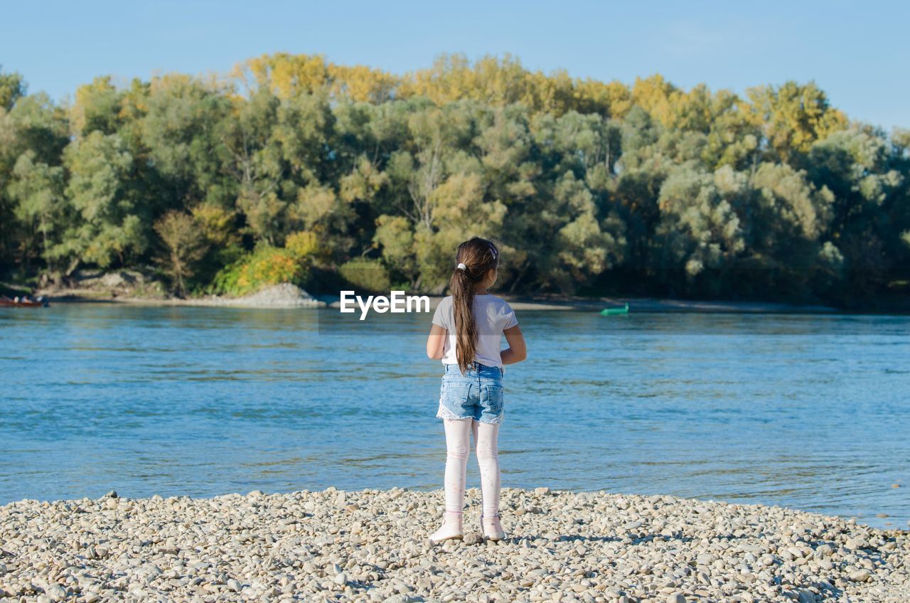 Full length of girl standing on lakeshore