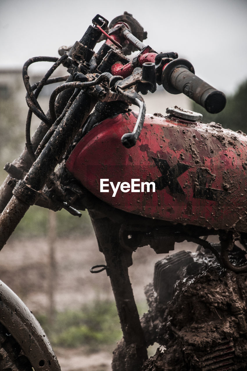 Close-up of abandoned motorcycle on field