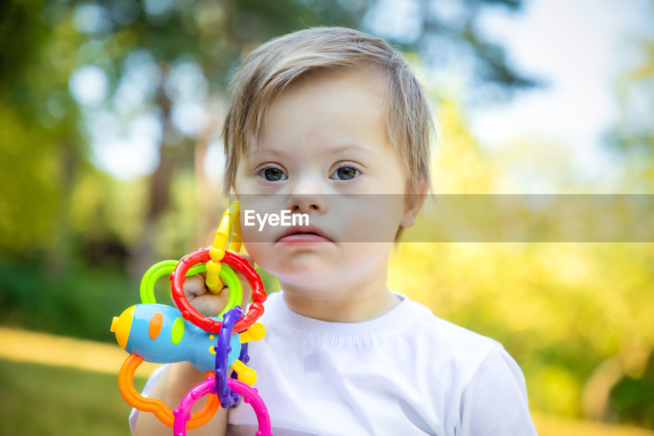 Portrait of boy holding toy in park