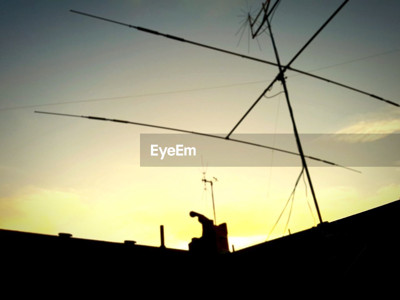 LOW ANGLE VIEW OF SILHOUETTE ELECTRICITY PYLON AGAINST SKY AT SUNSET