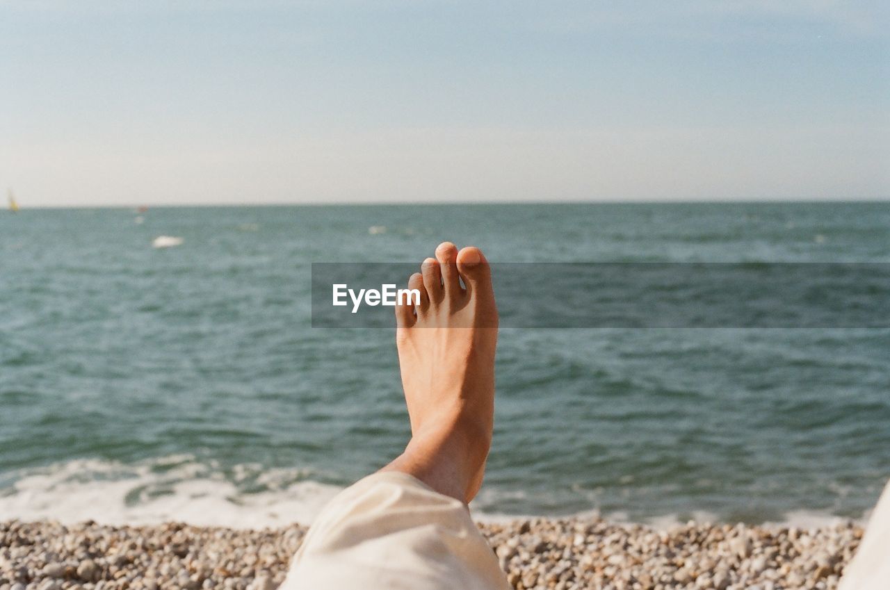 Low section of person relaxing at beach