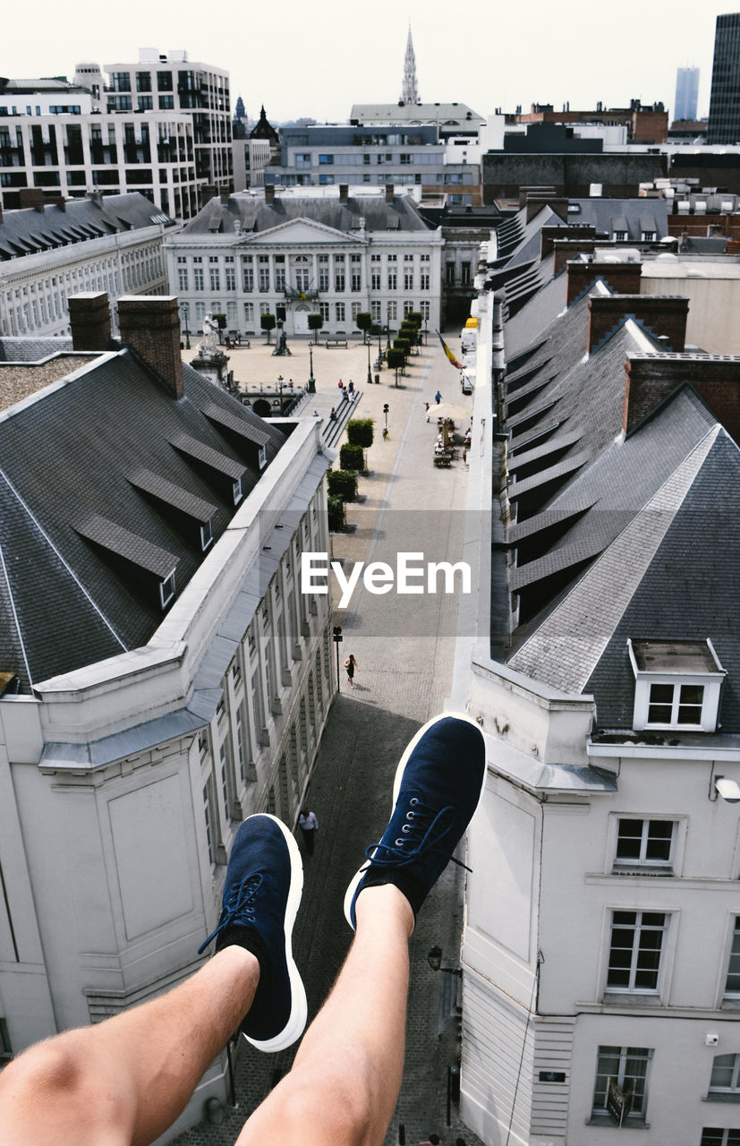 Low section of man legs over buildings in city