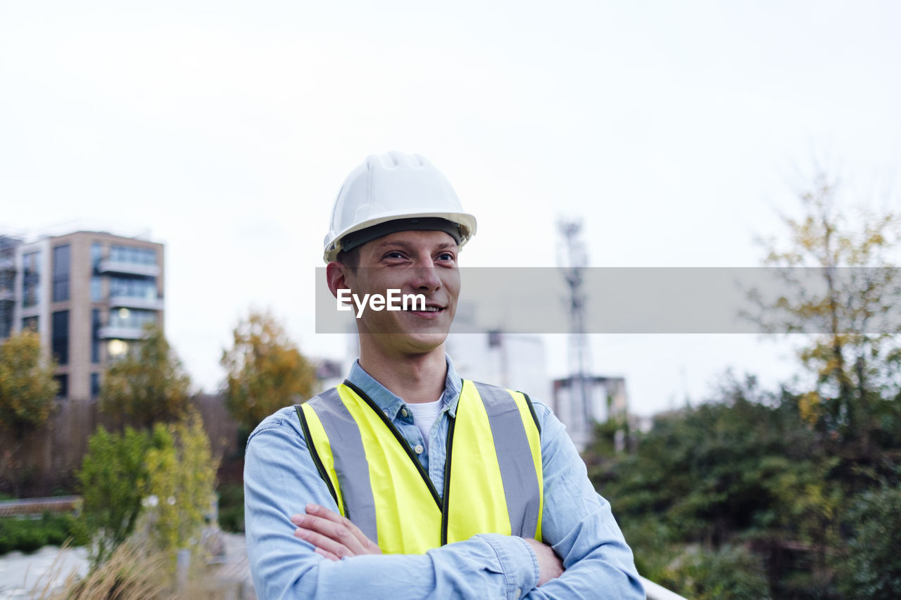 Thoughtful young engineer with arms crossed