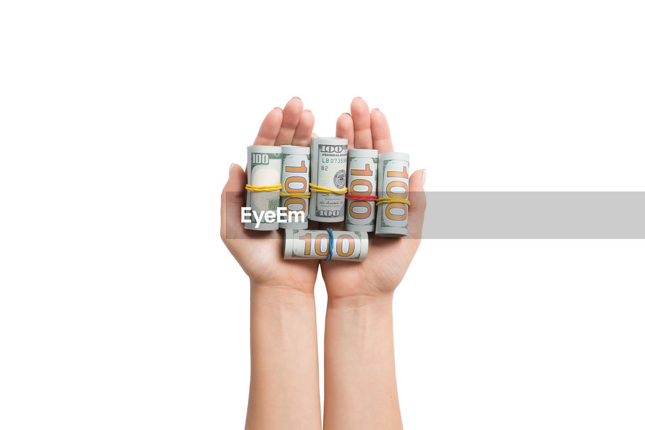 Cropped hands holding paper currency against white background