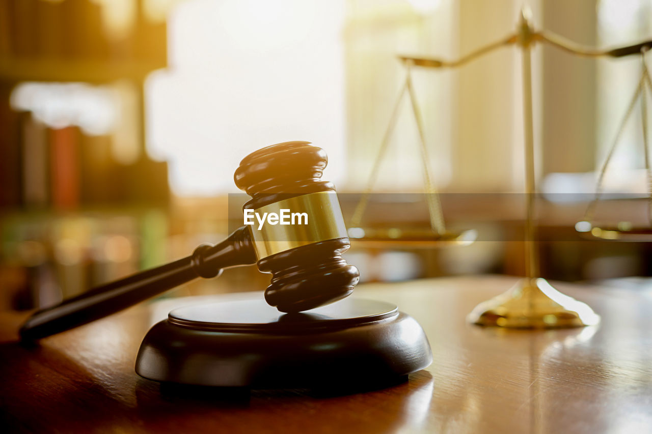 Close-up of gavel and weight scale on table