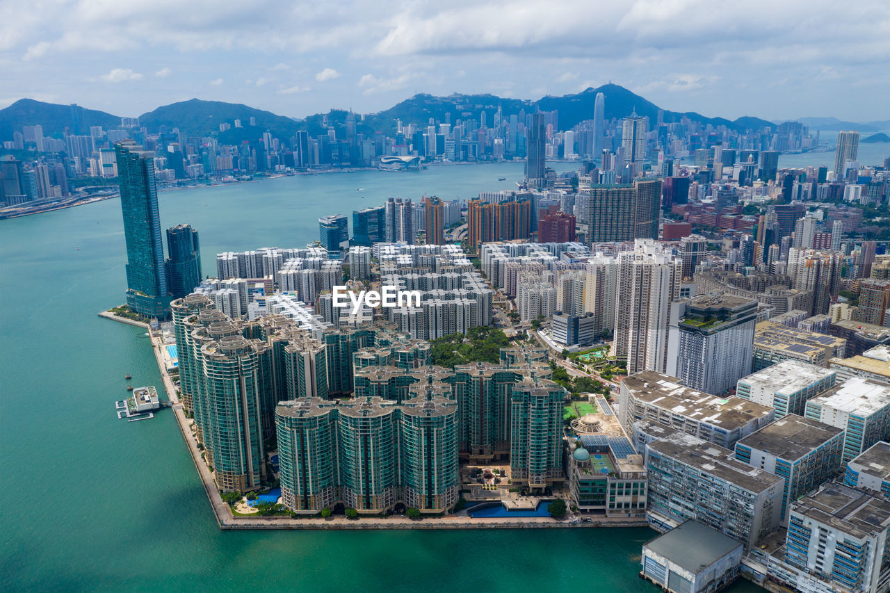 Aerial view of city by sea against sky