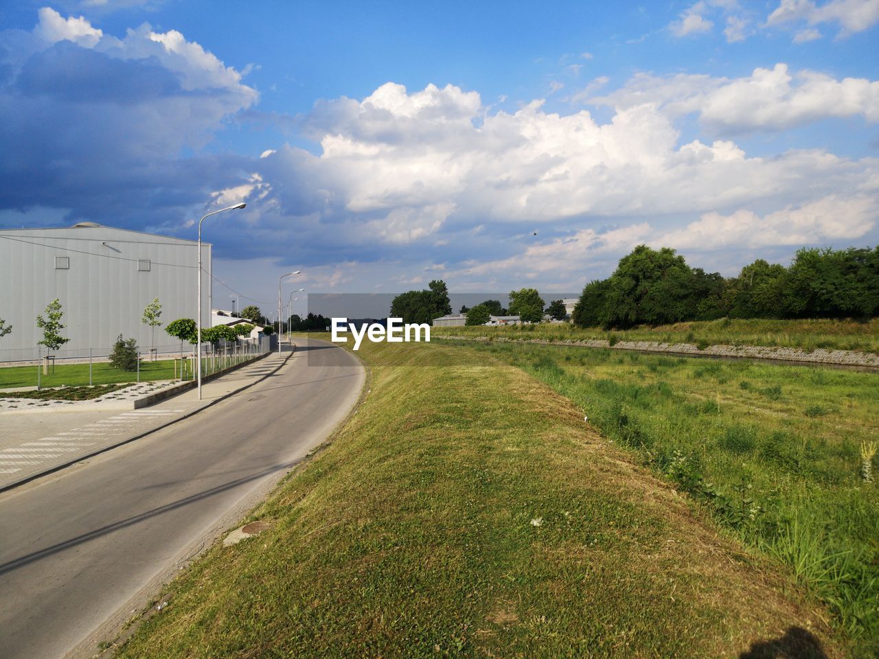 Road amidst field against sky