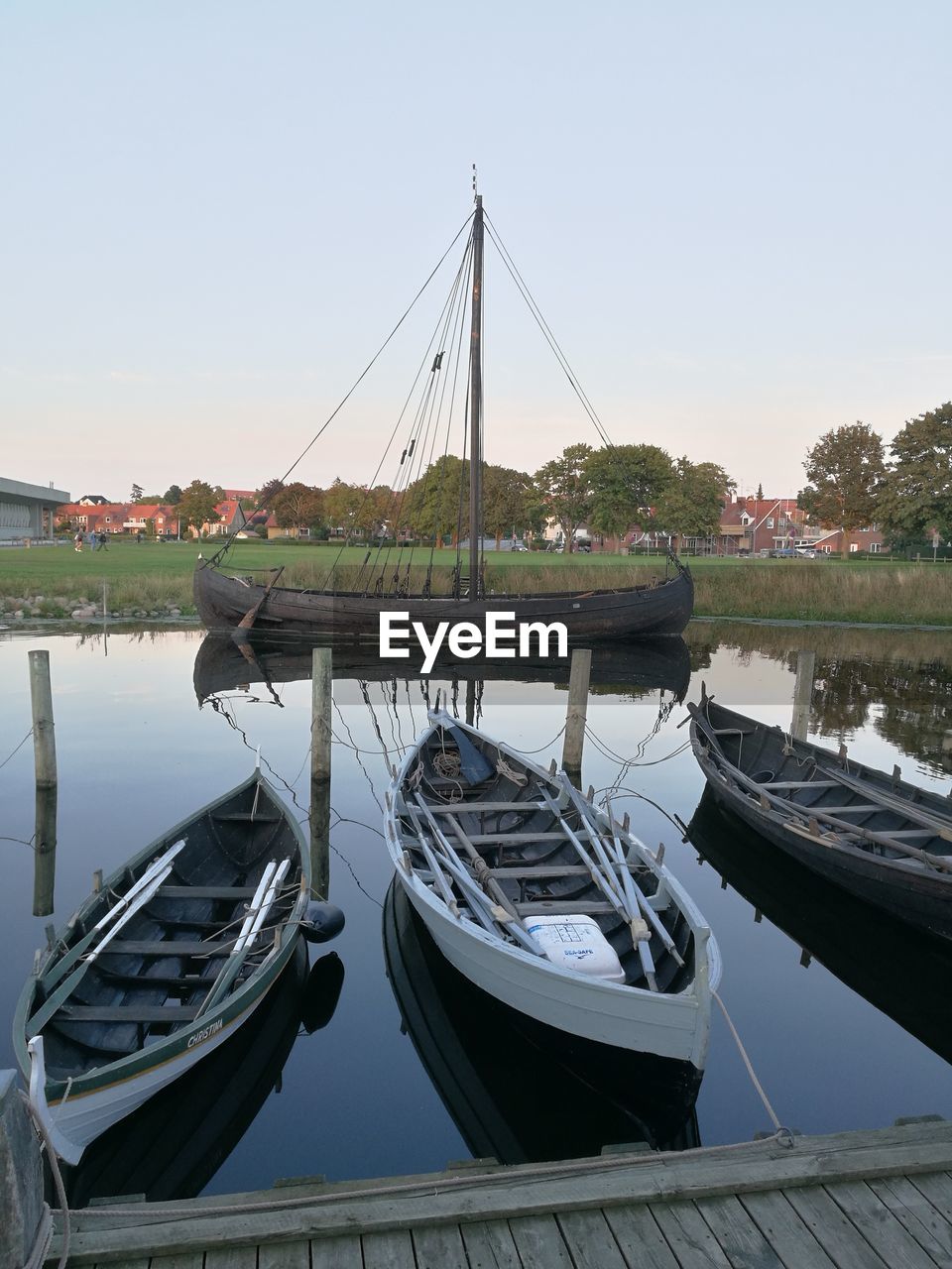 Boats moored in lake against clear sky