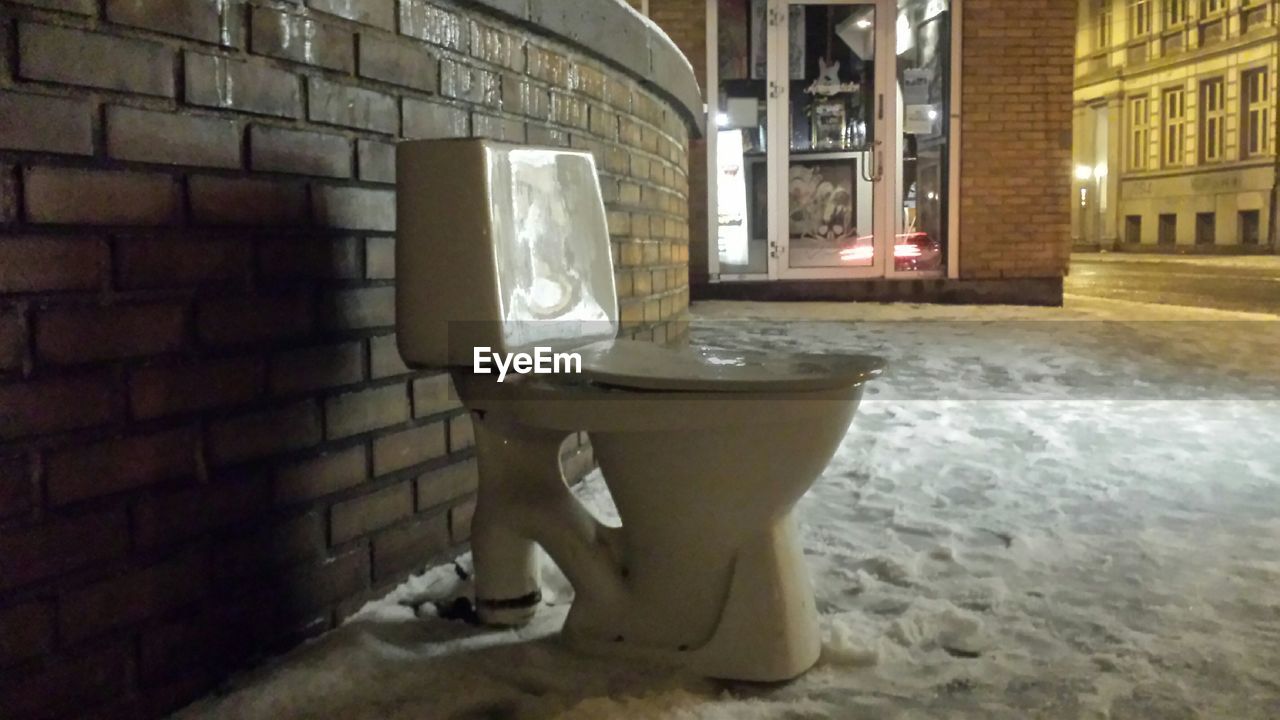 Toilet seat on snow covered street at night