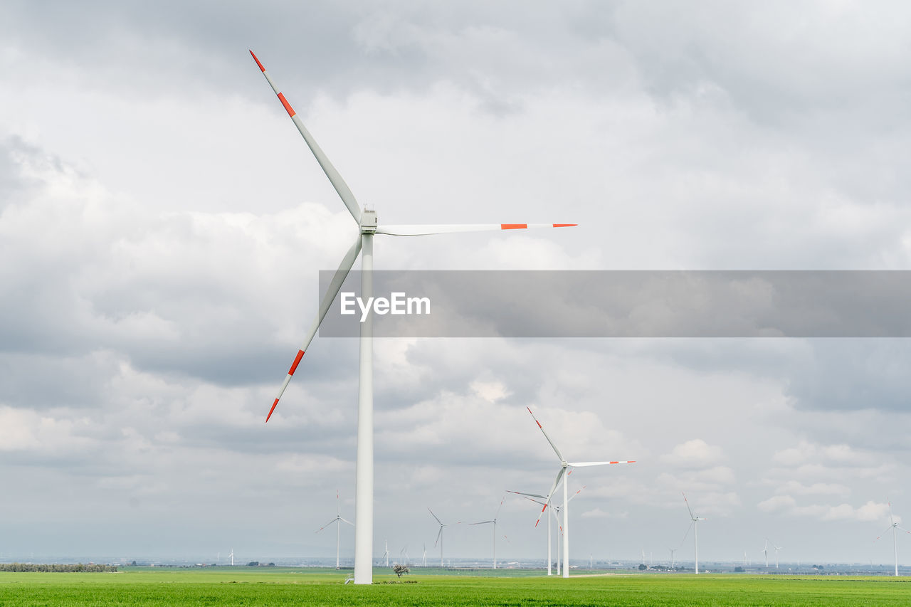 windmills on field against clear sky