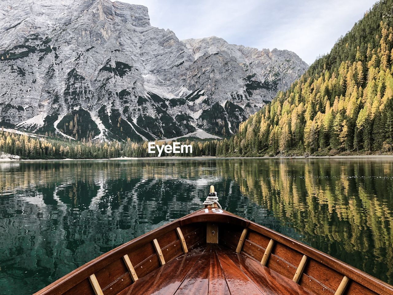 Boat on lake against snowcapped mountain