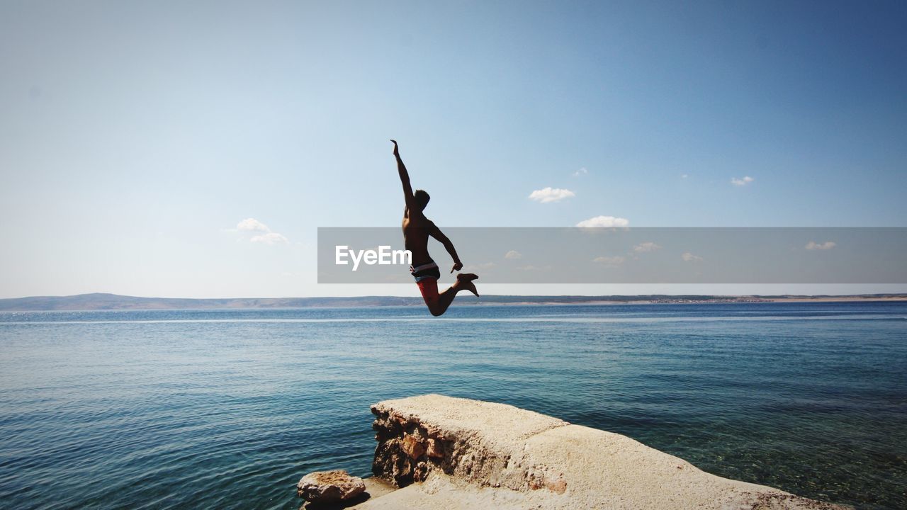 WOMAN JUMPING ON SEA