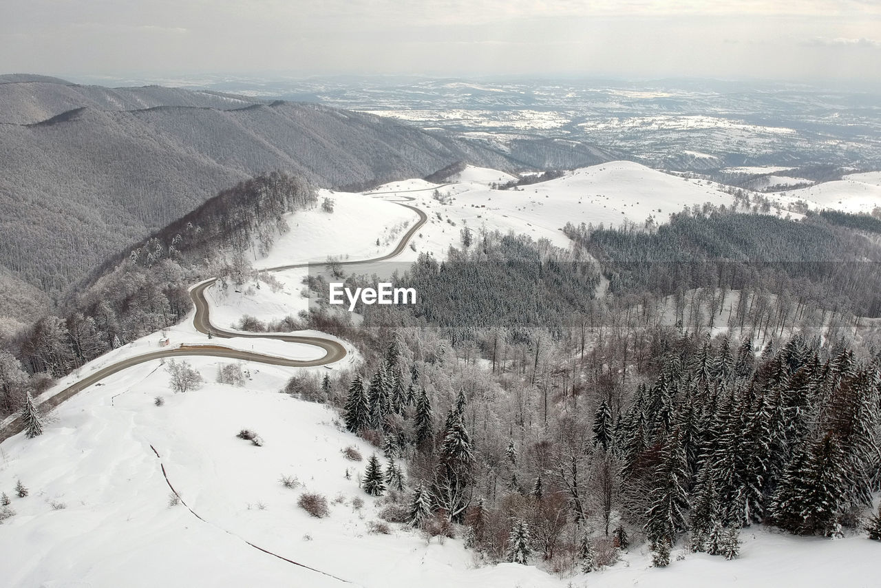 HIGH ANGLE VIEW OF SNOW COVERED ROAD