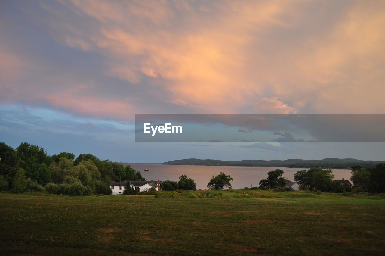 sky, environment, cloud, landscape, morning, nature, plant, beauty in nature, horizon, land, scenics - nature, grass, tree, dawn, field, tranquility, no people, sunlight, hill, rural scene, dramatic sky, tranquil scene, outdoors, architecture, travel, water, travel destinations, non-urban scene, plain, building, rural area, sunrise, idyllic, cloudscape, tourism, social issues, house, green