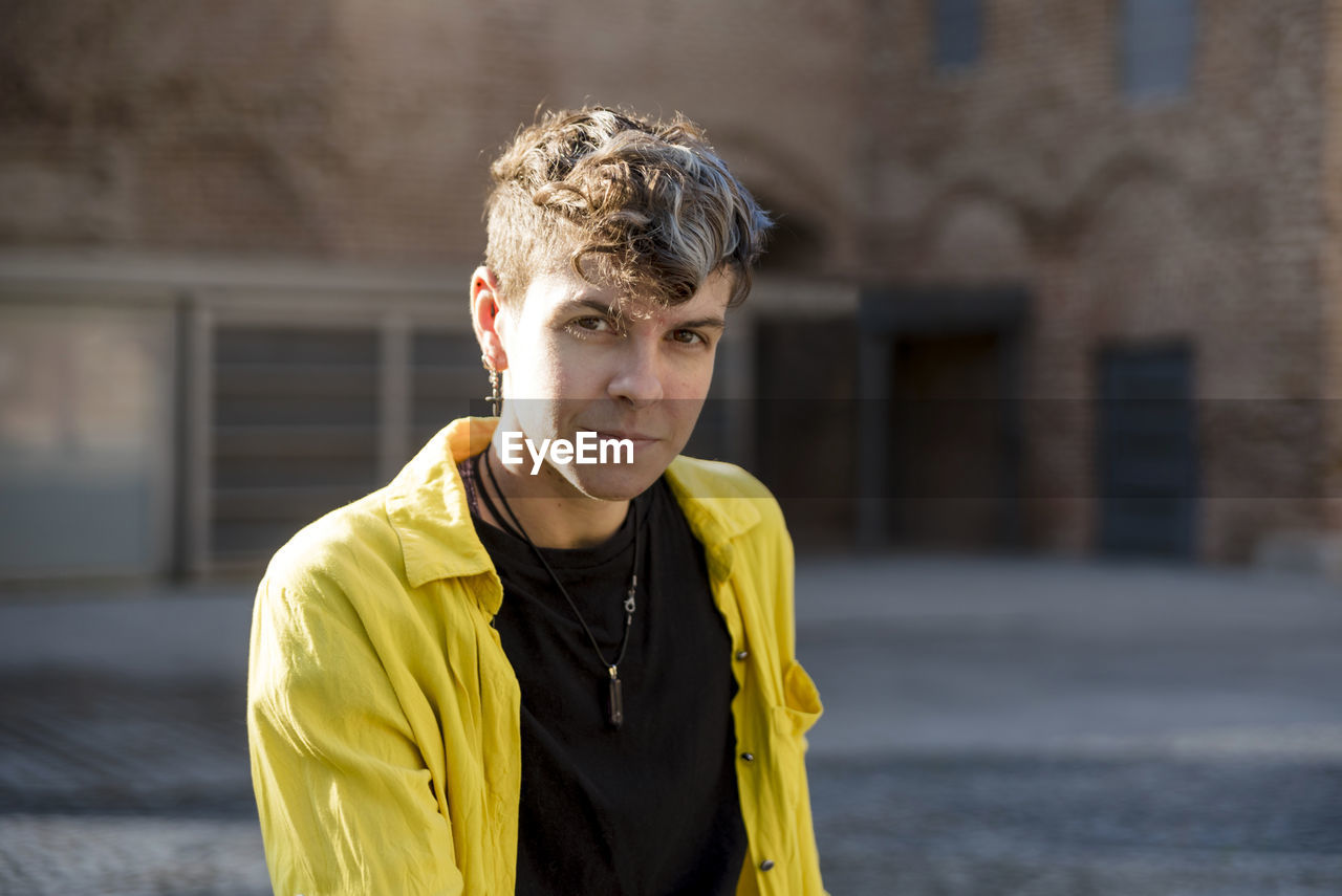 Portrait of a non binary person looking at camera while posing outdoors. person