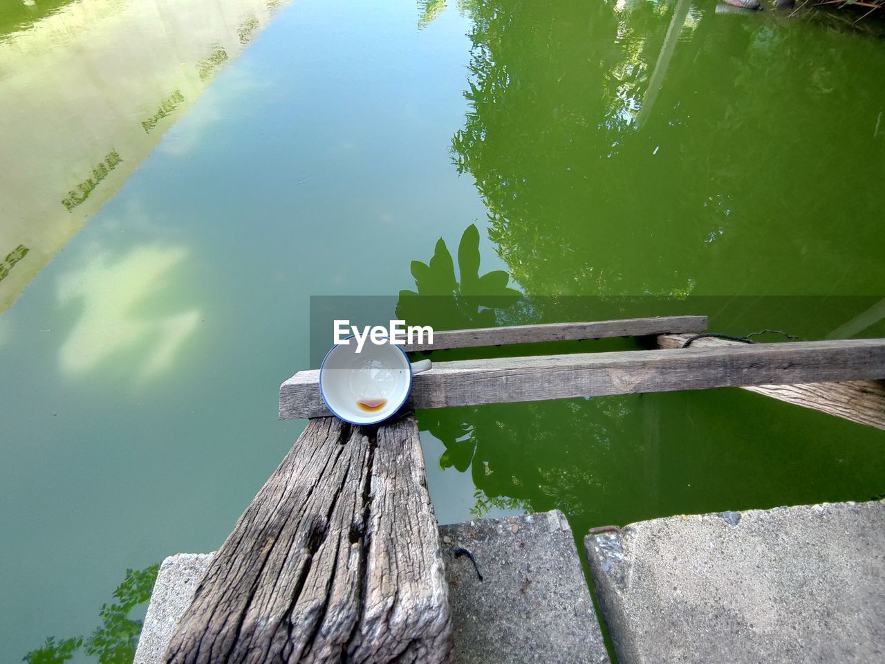 HIGH ANGLE VIEW OF WOODEN POST BY LAKE