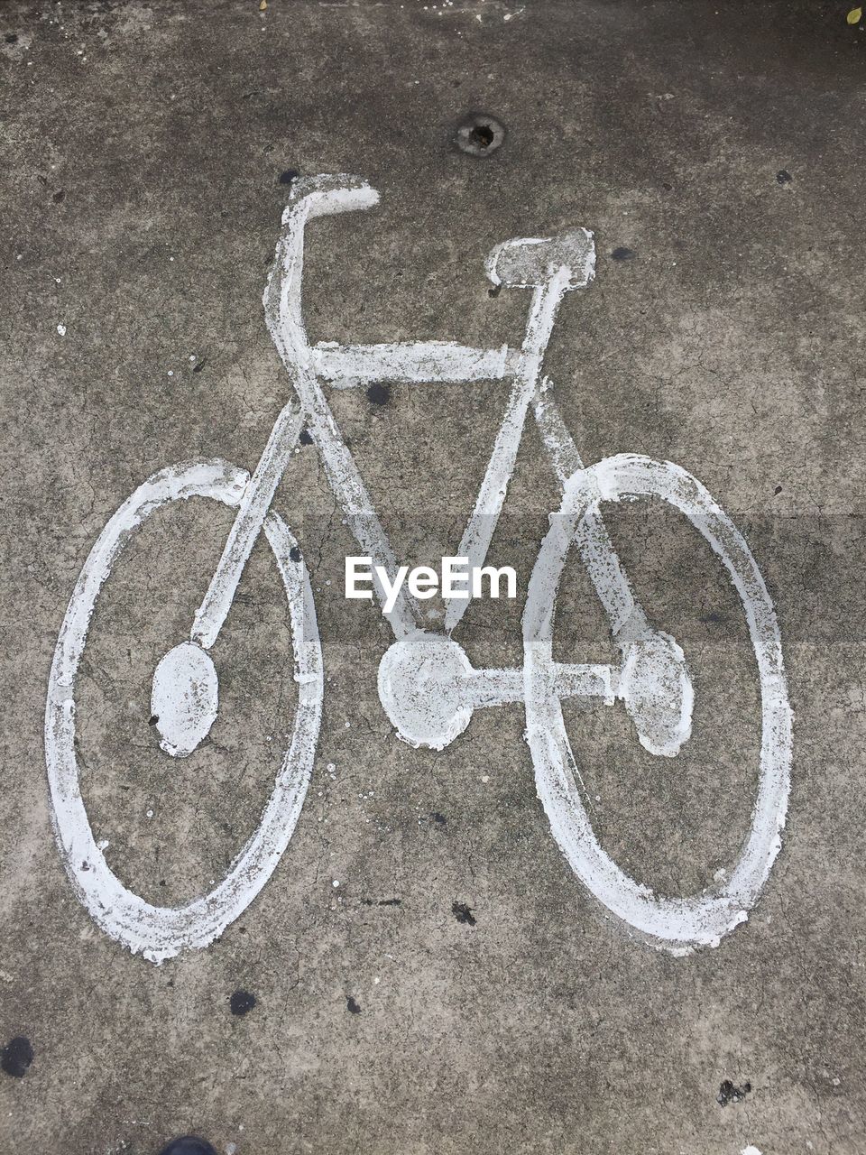 HIGH ANGLE VIEW OF ARROW SYMBOL ON ROAD