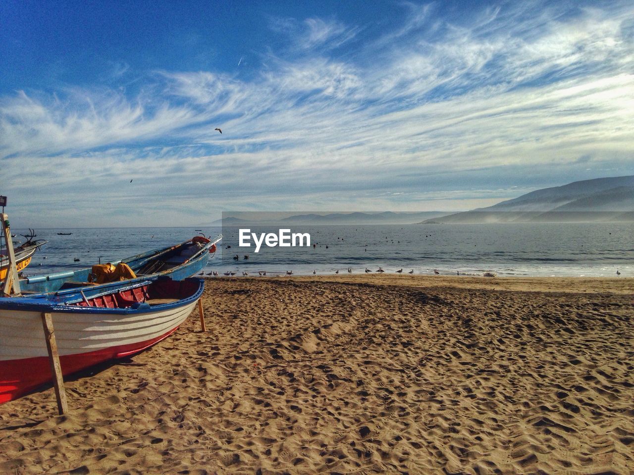 Cropped boat on shore against calm sea