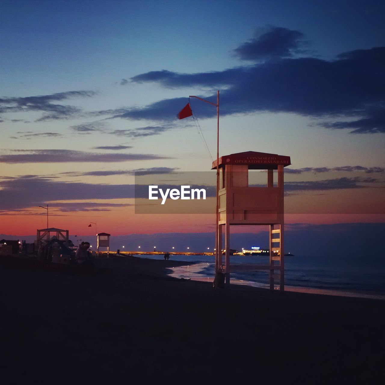 Lookout tower at beach against sky during sunset