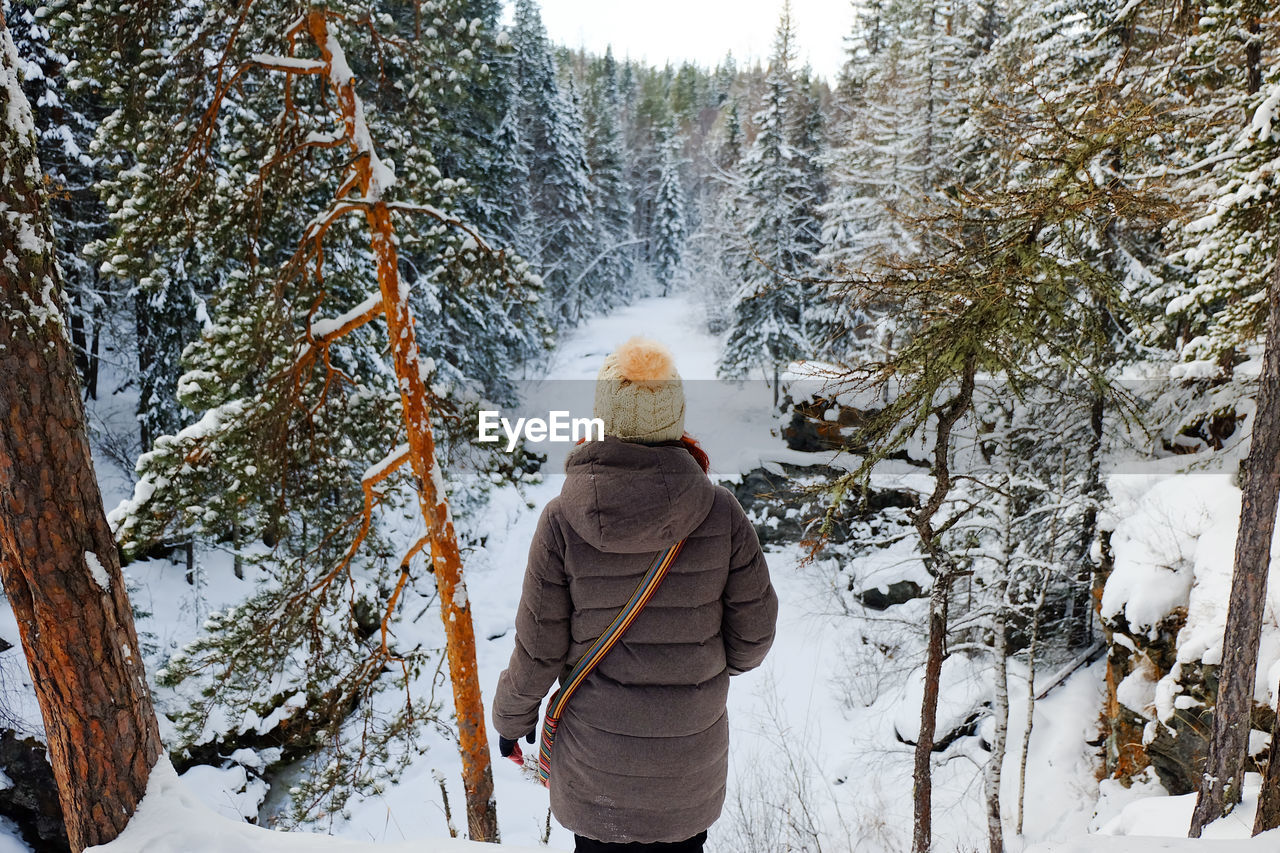 REAR VIEW OF PERSON STANDING IN SNOW