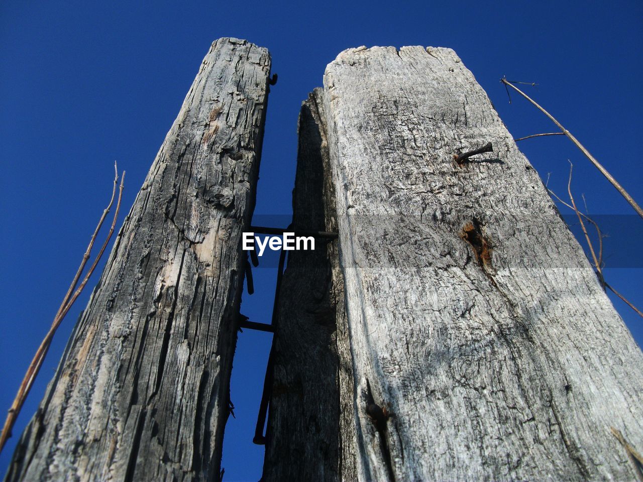 LOW ANGLE VIEW OF MAN CLIMBING AGAINST BLUE SKY