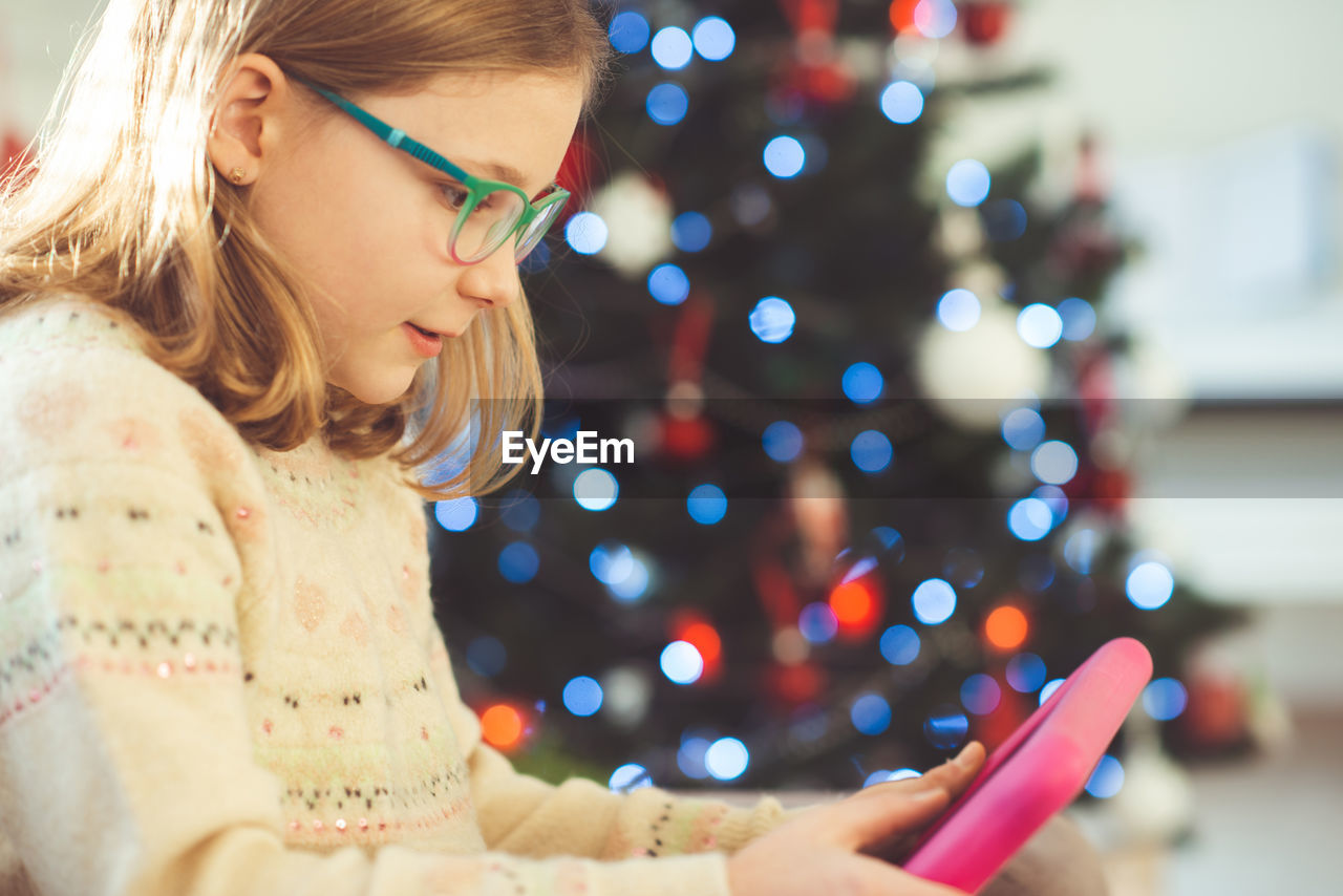 Girl using digital tablet at home during christmas