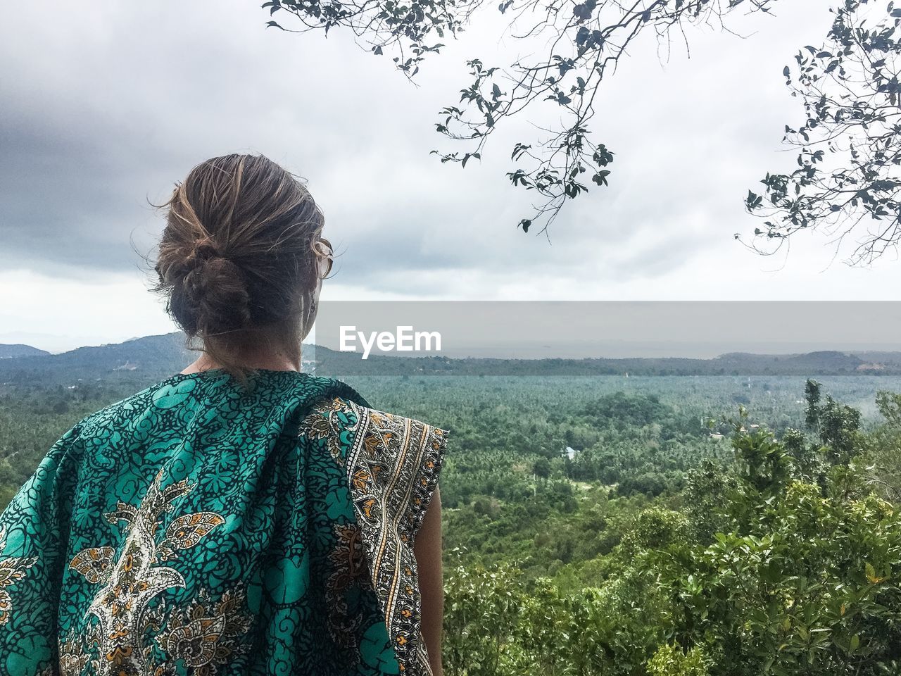 Rear view of woman on field against sky