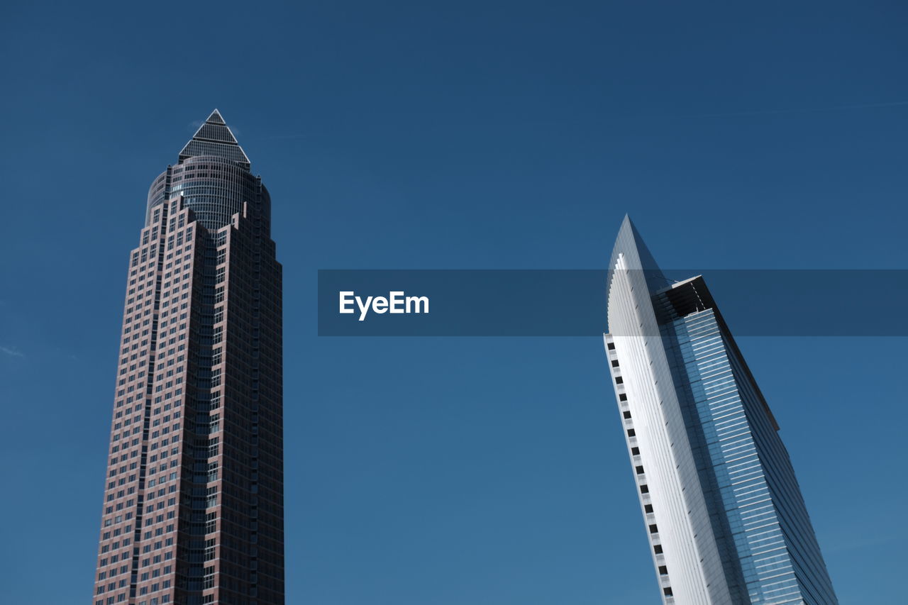 Low angle view of messeturm against blue sky