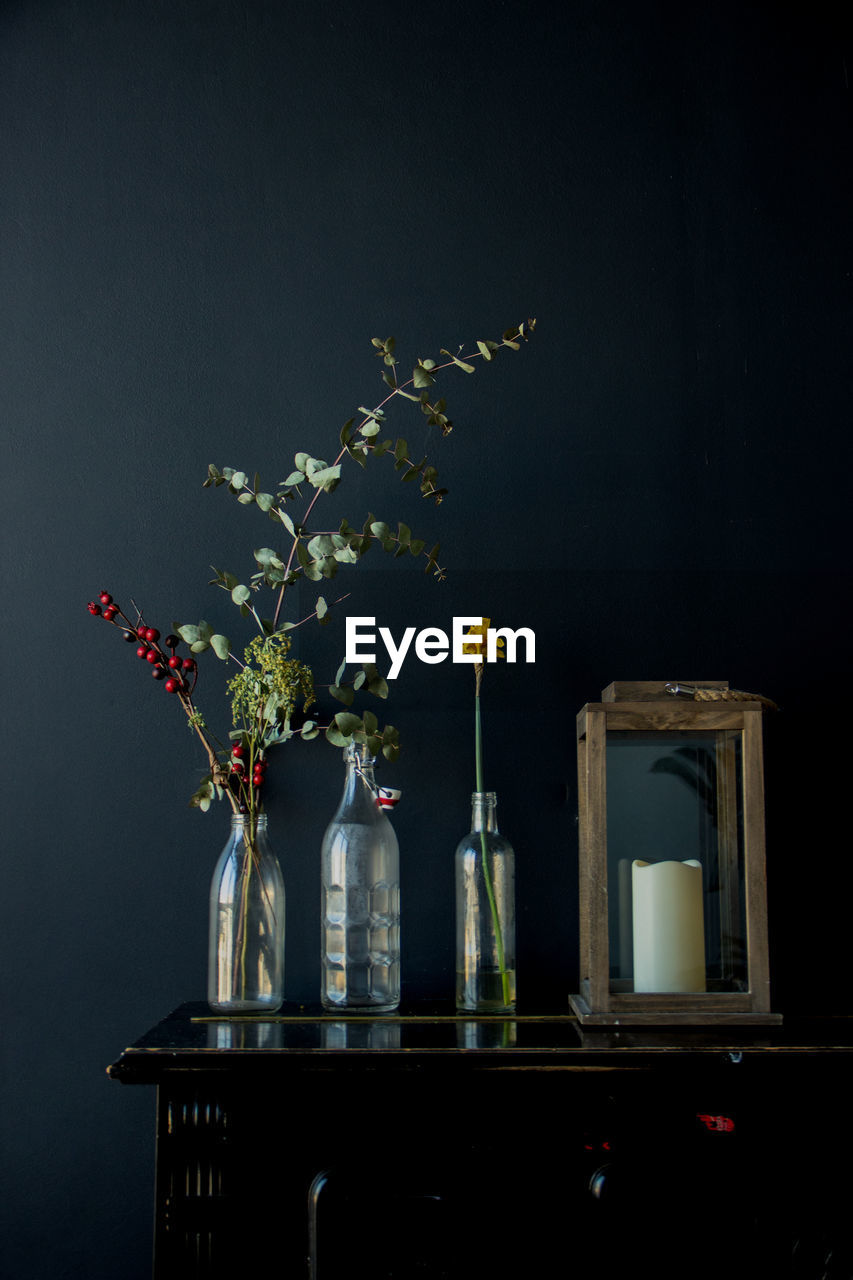 Close-up of flower vase on table against black background