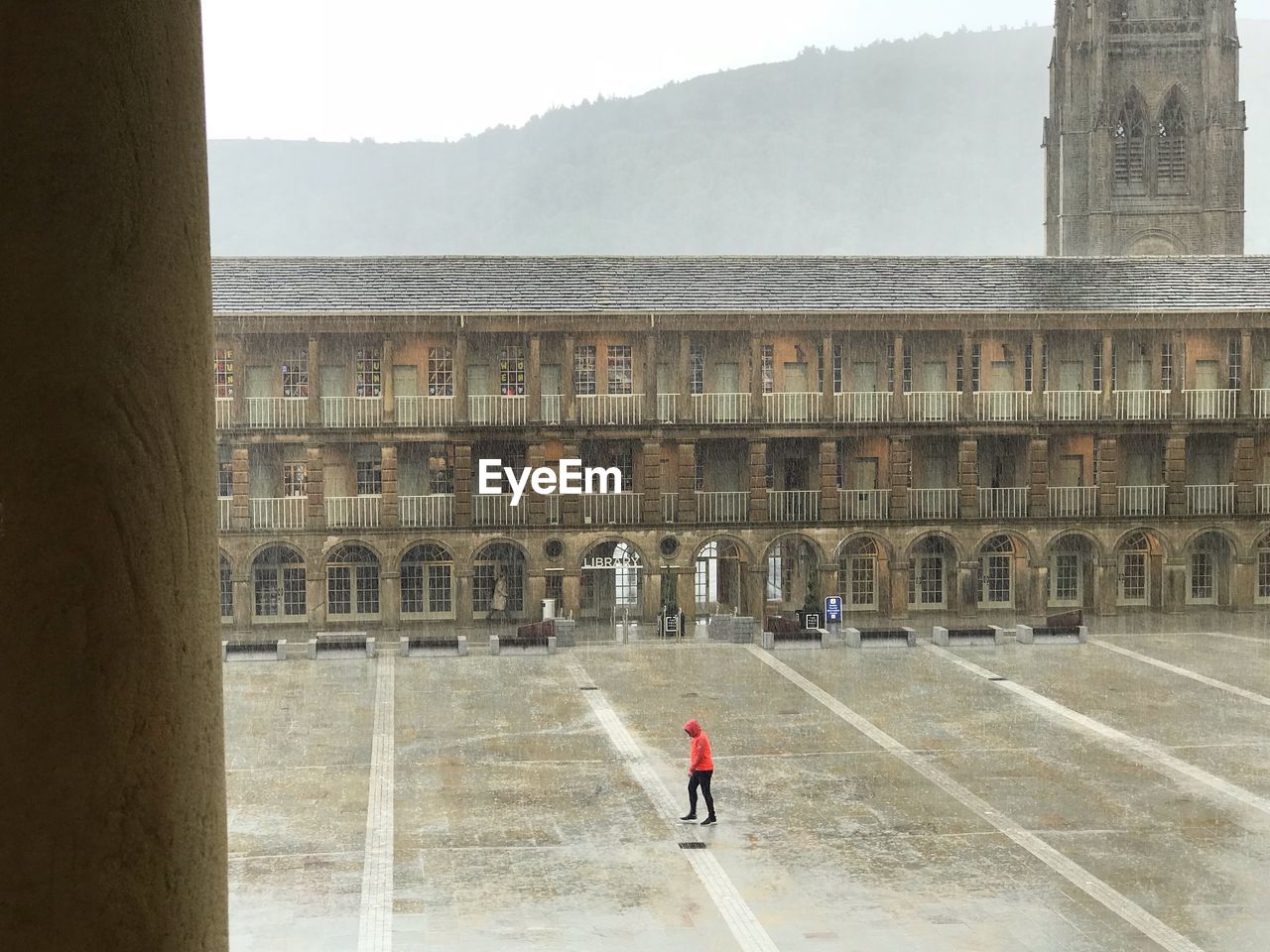 MAN WALKING BY HISTORIC BUILDING