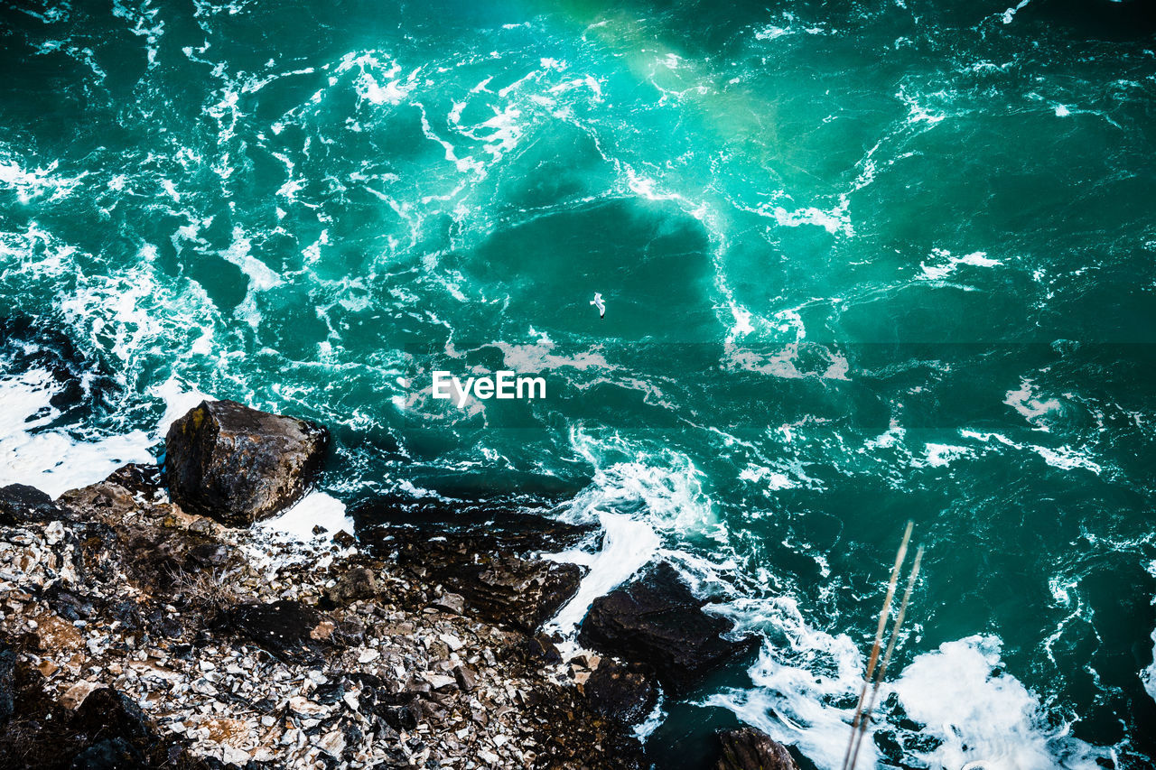HIGH ANGLE VIEW OF ROCK FORMATIONS AT SEA