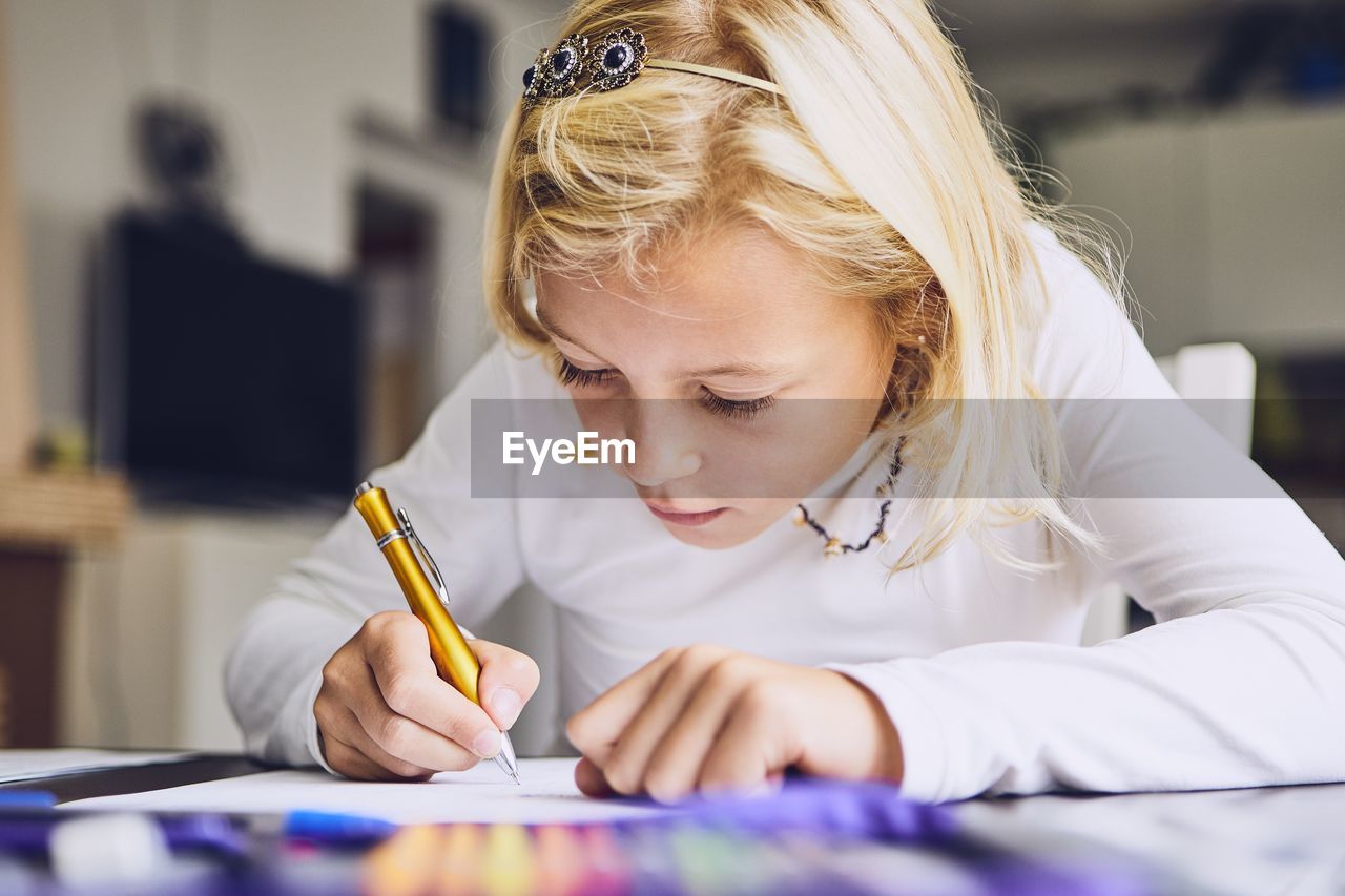 Girl writing on paper at table