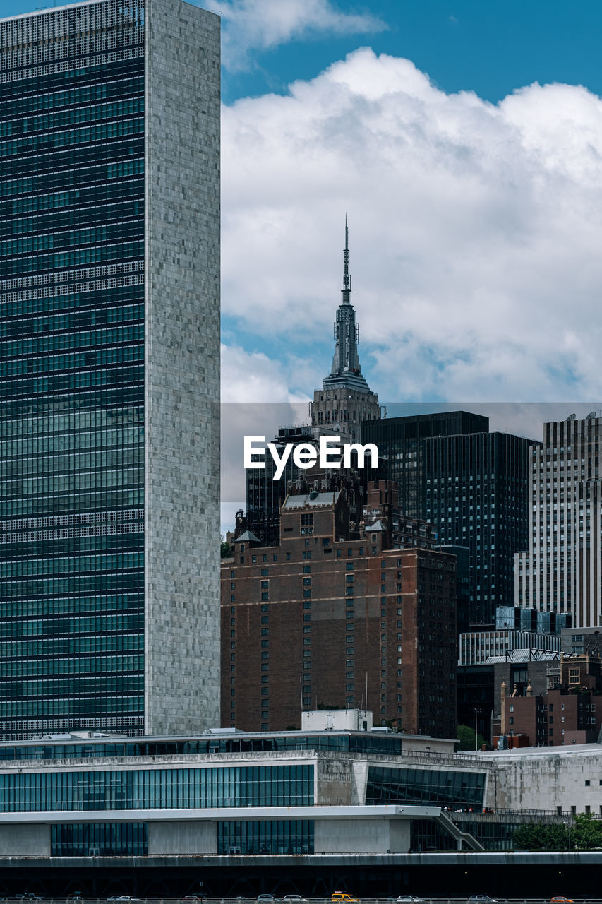 Buildings in city against cloudy sky