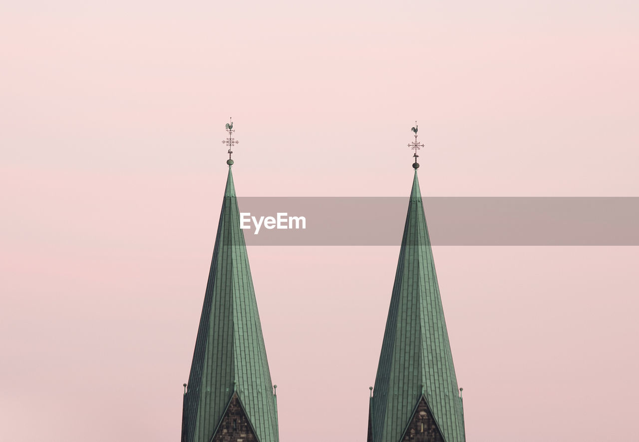 Low angle view of steeples against sky